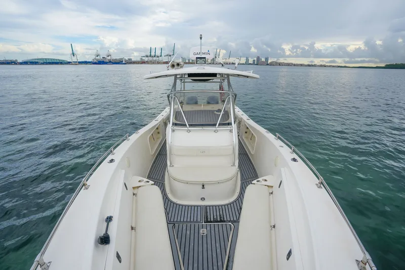 Slide: The Image of 2004 Pursuit 3070 Center Console boat on calm water, with city skyline in background. - 24