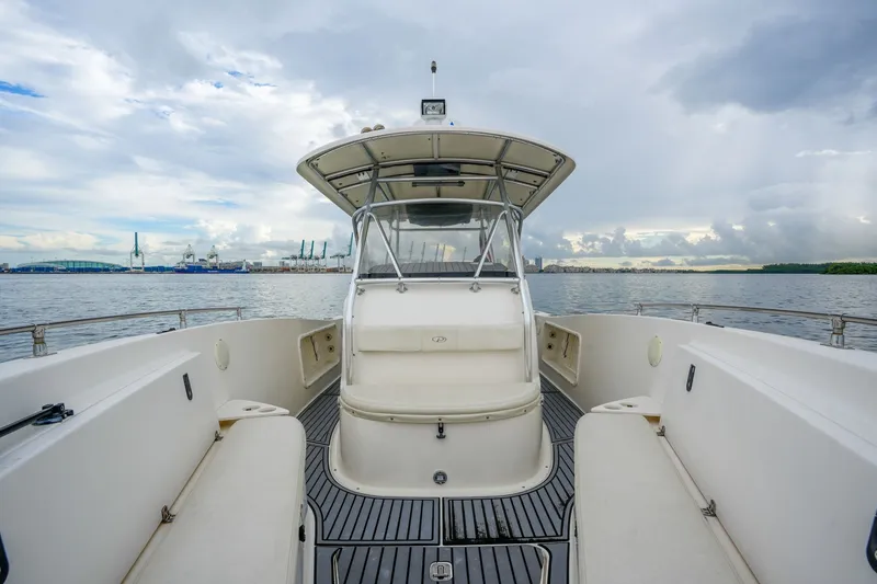 Slide: The Image of 2004 Pursuit 3070 Center Console boat on calm water with cloudy sky backdrop. - 25