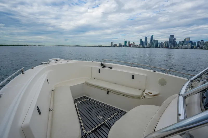 Slide: The Image of 2004 Pursuit 3070 Center Console boat with city skyline view on a cloudy day. - 18