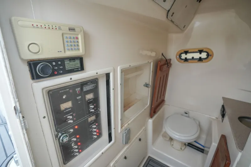 Slide: The Image of Interior of 2004 Pursuit 3070 Center Console boat with control panels and marine toilet. - 32