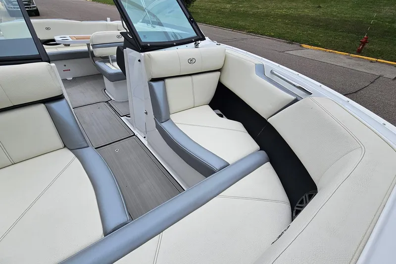 Slide: The Image of 2022 Cobalt CS23 boat interior with white and gray seating, docked near grassy area. - 18