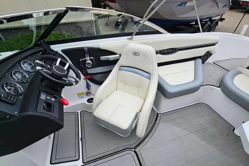 Slide: The Image of 2022 Cobalt CS23 boat interior with steering wheel and white seating. - 10