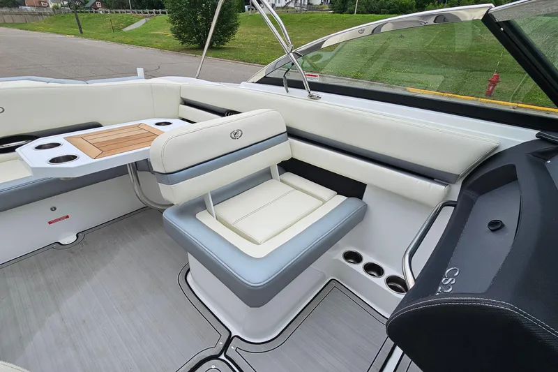 Slide: The Image of 2022 Cobalt CS23 boat interior with white seating and wooden table. - 11
