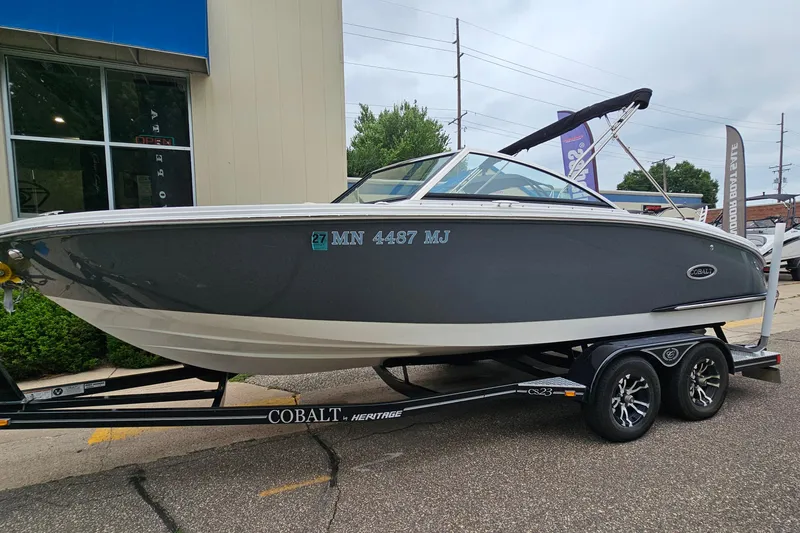 The Image of 2022 Cobalt CS23 boat on trailer, parked outside a building. - 1