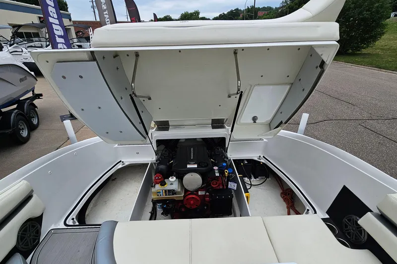 Slide: The Image of 2022 Cobalt CS23 boat engine compartment open, showcasing internal components and storage. - 21