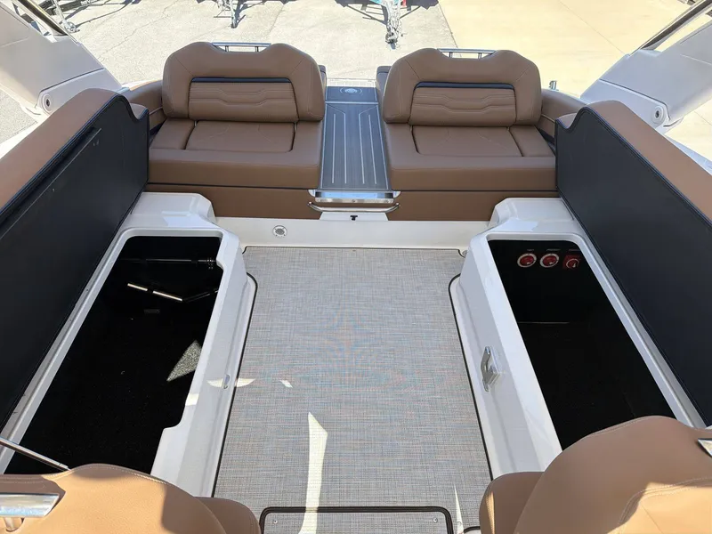 Slide: The Image of The image shows the cockpit of a 2026 Regal LS9 boat with brown seating and storage compartments. - 26