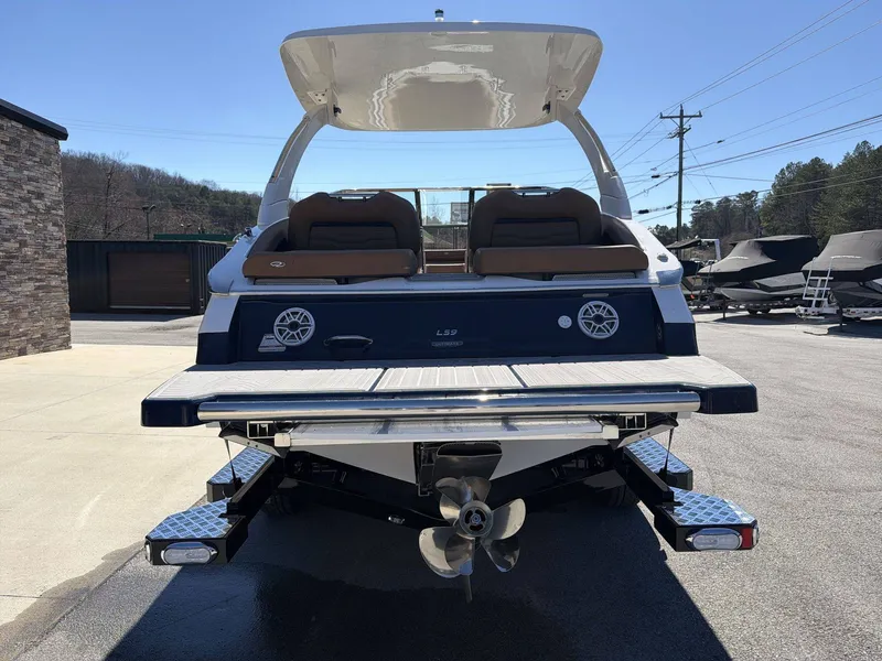 Slide: The Image of The image shows a 2026 Regal LS9 boat parked on a lot. It features a modern, stylish rear with two speakers and a propeller. - 7