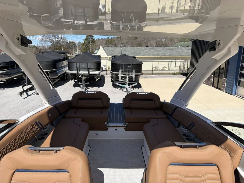 Slide: The Image of The image shows the interior of a 2026 Regal LS9 boat with brown seating and a table. - 5
