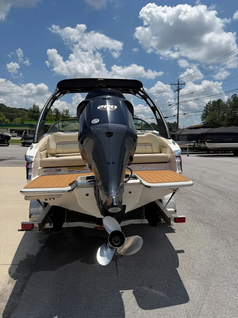 Slide: The Image of A 2021 Regal LX2 boat with a large outboard motor, parked on a trailer. - 10