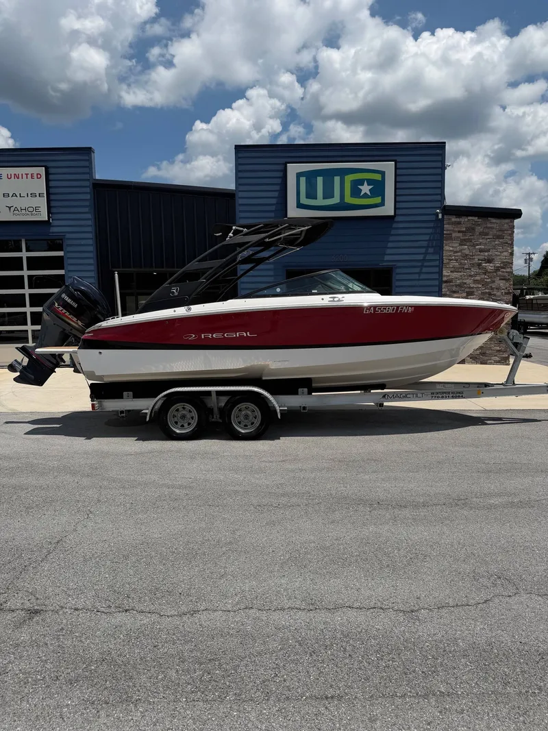 Slide: The Image of A red and white 2021 Regal LX2 boat is on a trailer in front of a building. - 15