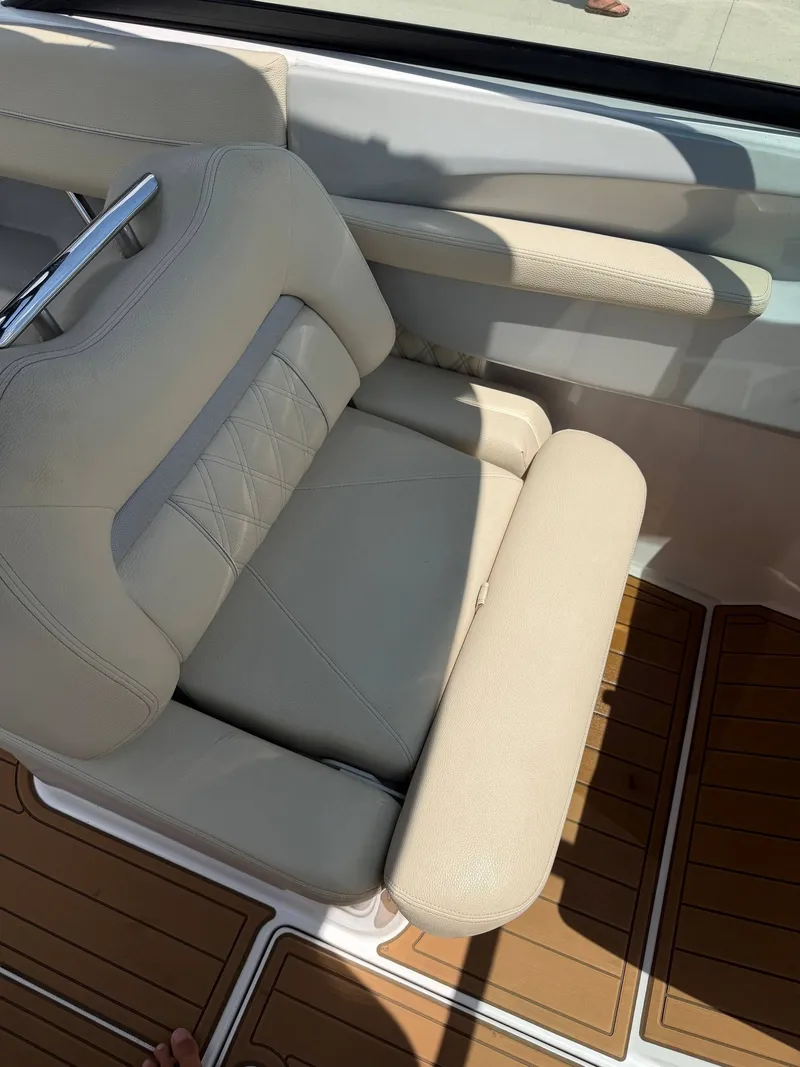 Slide: The Image of A beige leather seat on a boat with wooden flooring and metal handles. - 12