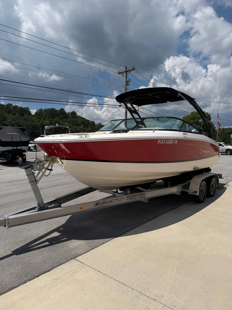 Slide: The Image of A red 2021 Regal LX2 boat is on a trailer in a parking lot. - 7