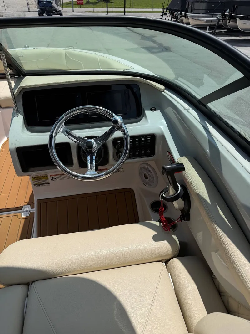 Slide: The Image of The image shows the cockpit of a 2021 Regal LX2 boat with a sleek steering wheel and beige seating. - 14