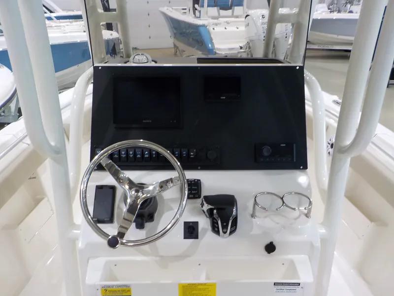 Slide: The Image of The image shows the helm of a Key West 239 FS boat with a steering wheel and instruments. - 8