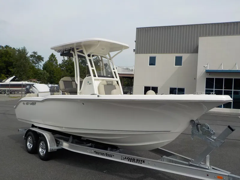 Slide: The Image of A 2027 Key West 239 FS boat on a trailer in front of a modern building. - 5