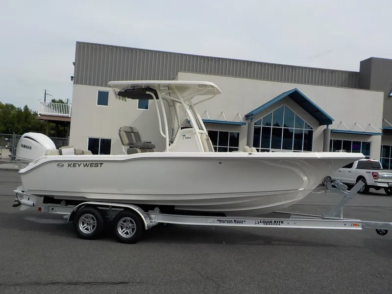 Slide: The Image of A 2027 Key West 239 FS boat on a trailer in front of a modern building. - 3