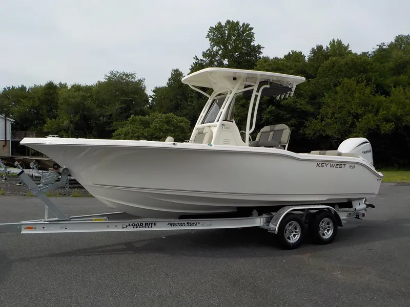 The Image of A 2027 Key West 239 FS boat on a trailer, surrounded by trees. - 1