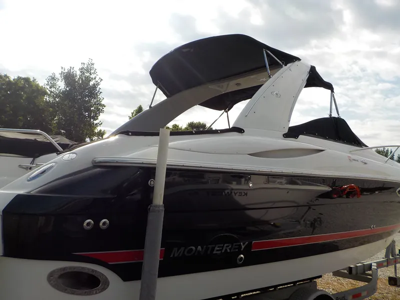 Slide: The Image of A 2006 Monterey 298SC Super Sport boat with a black and white hull, on a trailer. - 3