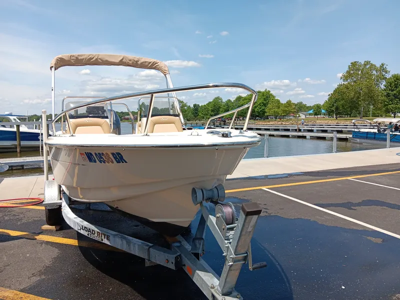 Slide: The Image of A 2020 Scout 175 Sport Dorado boat on a trailer in a marina area. - 13