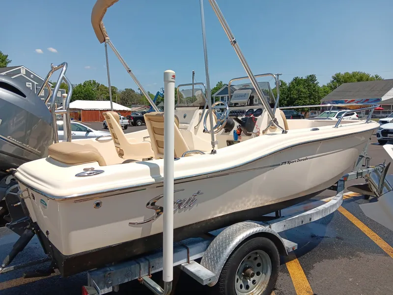 Slide: The Image of A 2020 Scout 175 Sport Dorado boat on a trailer, featuring beige interior and a Bimini top. - 15