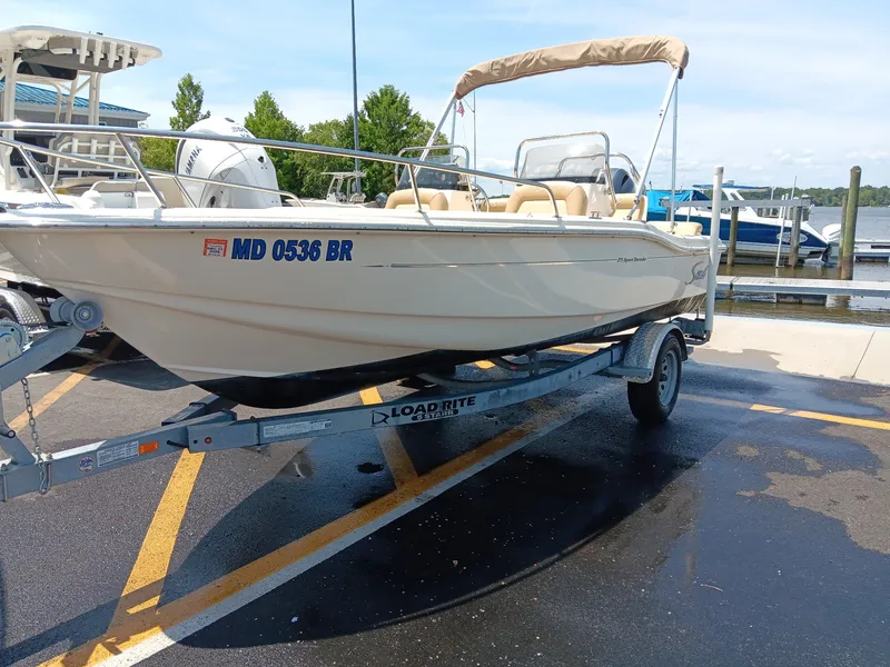 Slide: The Image of A 2020 Scout 175 Sport Dorado boat on a trailer, parked on a wet parking lot. - 12