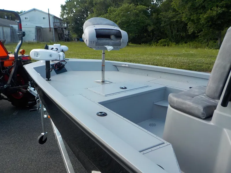 Slide: The Image of The image shows a 2026 G3 Bay 19 GX boat. It features a gray deck with a raised seat and console. Trees and a building are visible in the background. - 9