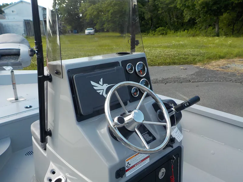 Slide: The Image of The image shows the helm of a G3 Bay 19 GX boat with a steering wheel and gauges. - 13