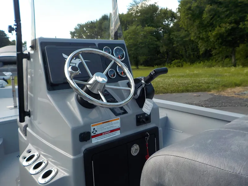 Slide: The Image of The image shows the helm of a G3 Bay 19 GX boat with a steering wheel and gauges. - 14