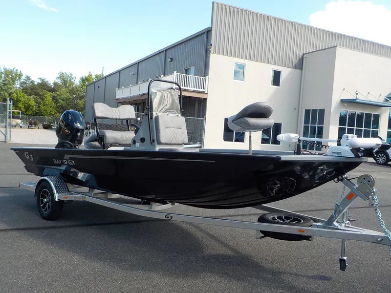 Slide: The Image of A 2026 G3 Bay 19 GX boat on a trailer parked in front of a building. - 5