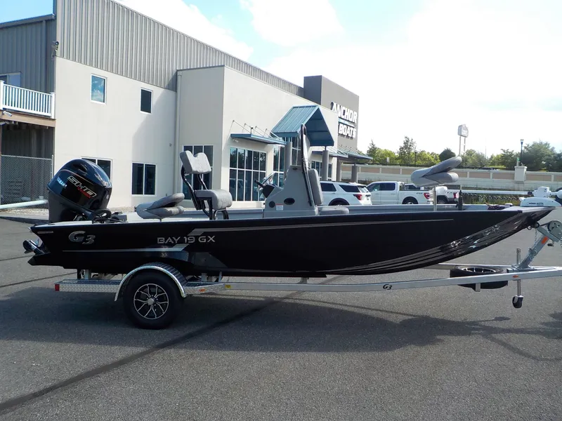 Slide: The Image of A black 2026 G3 Bay 19 GX boat on a trailer in front of a building. - 4