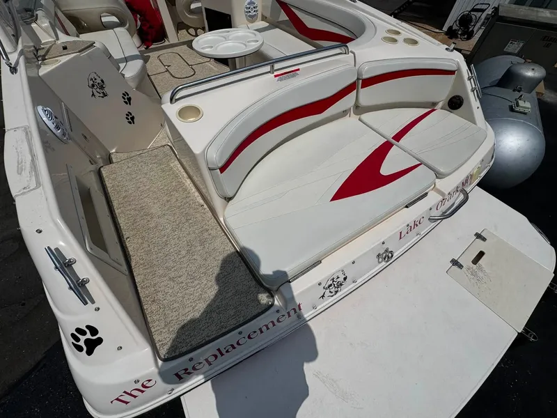 Slide: The Image of The image shows the stern of a 2006 Rinker 282 BR boat with white and red seating. - 12