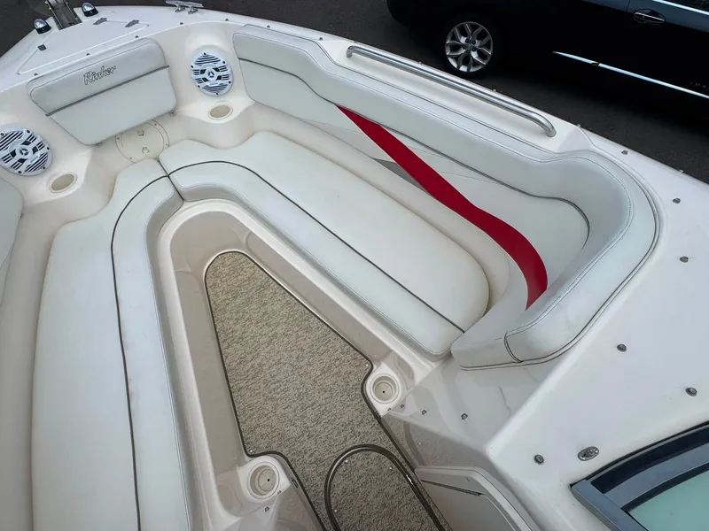 Slide: The Image of The image shows the bow area of a 2006 Rinker 282 BR boat with white upholstery and red accents. - 4