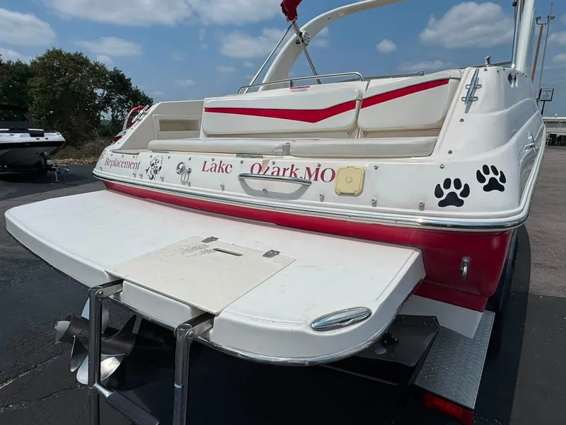 Slide: The Image of A 2006 Rinker 282 BR boat with personalized decals and a swim platform at the stern. - 18