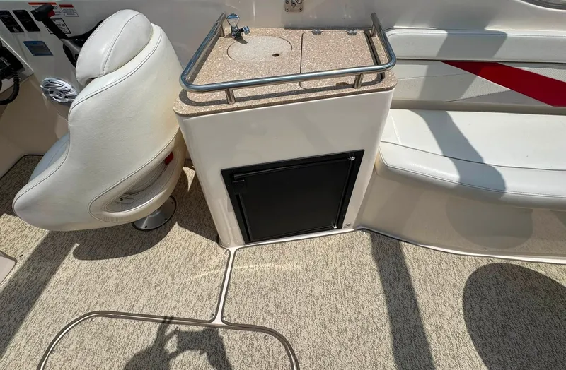 Slide: The Image of The image shows the interior of a 2006 Rinker 282 BR boat with a seating area and small countertop. - 21