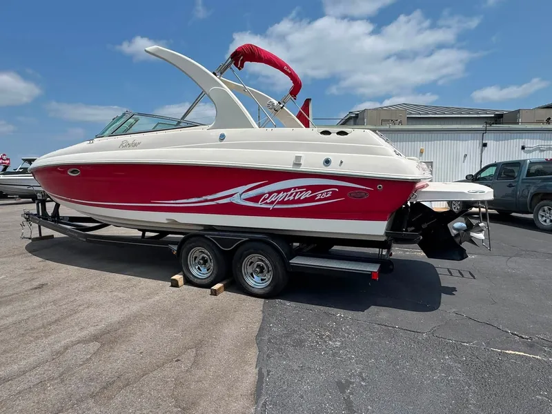 Slide: The Image of A red 2006 Rinker 282 BR boat on a trailer in a parking lot. - 19