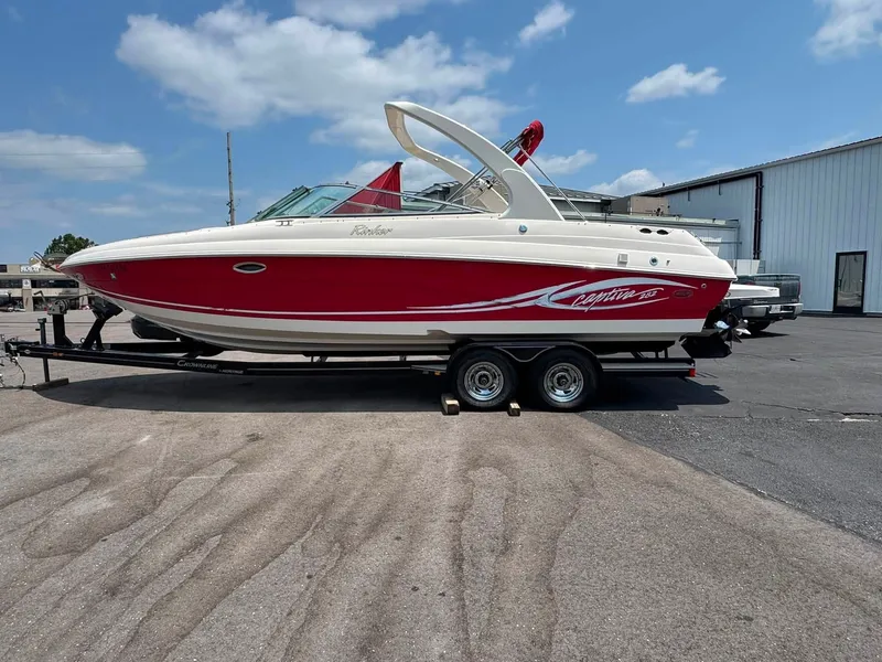 Slide: The Image of A red 2006 Rinker 282 BR boat is on a trailer in a parking lot. - 20