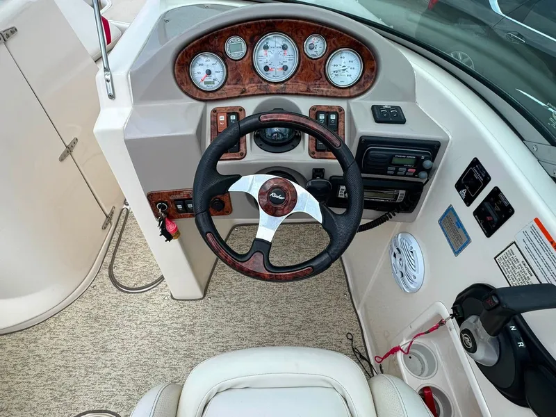 Slide: The Image of The image shows the cockpit of a 2006 Rinker 282 BR with a sleek dashboard and leather steering wheel. - 16