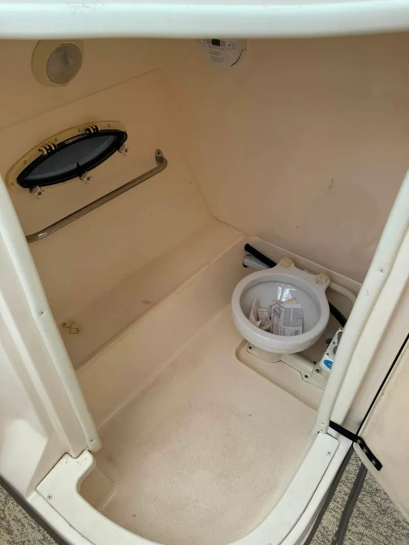 Slide: The Image of The image shows a compact boat toilet with a small sink and a porthole. - 17