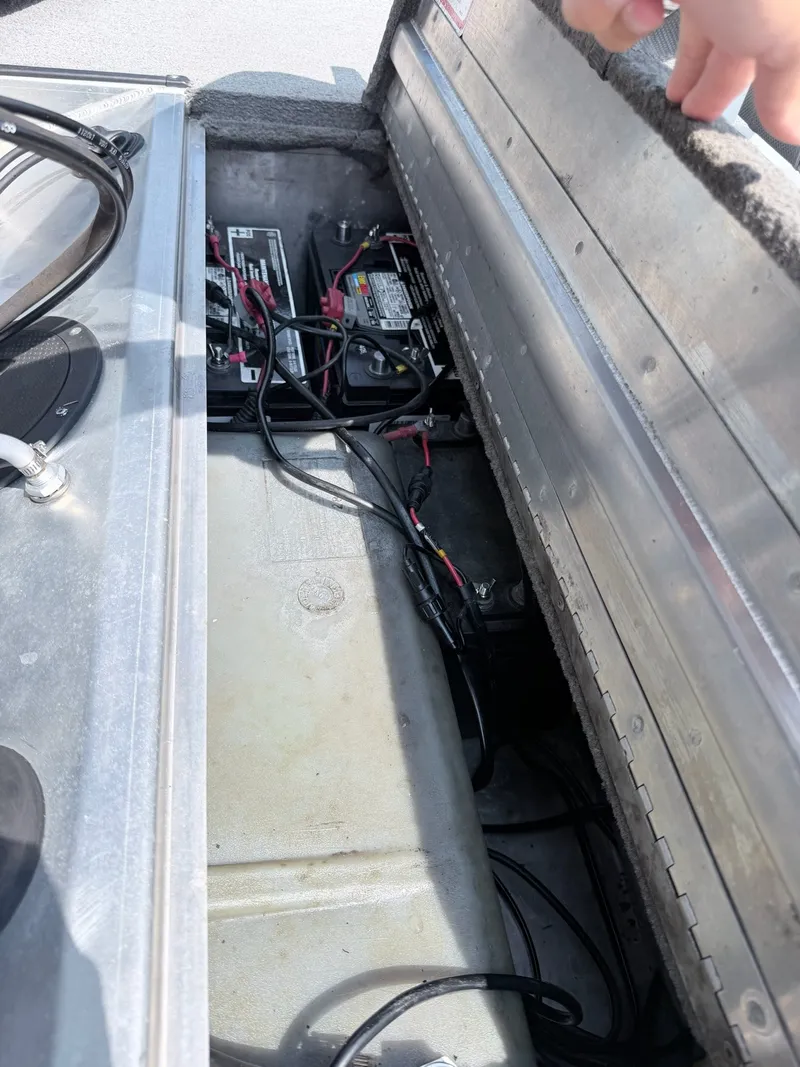 Slide: The Image of An open storage compartment in the boat reveals batteries and wiring. - 24