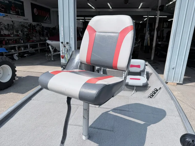 Slide: The Image of A gray and red seat on a 2011 Tracker Pro 165 boat, inside a workshop. - 10