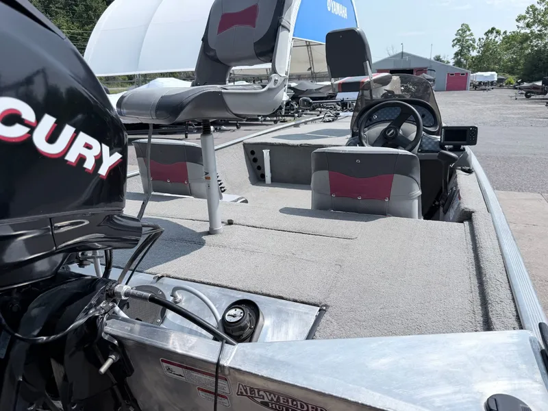 Slide: The Image of A 2011 Tracker Pro 165 with gray carpeting and two padded seats. A Mercury engine is visible. - 14