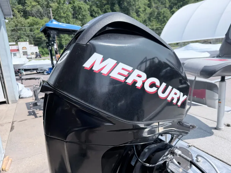 Slide: The Image of A Mercury outboard motor is attached to a boat on a trailer. Trees are visible in the background. - 13