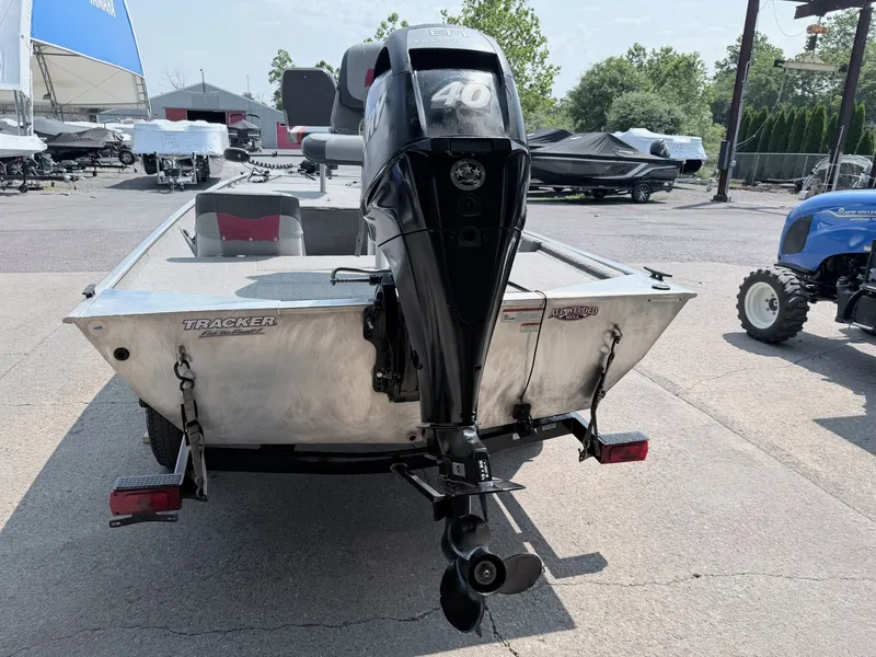 Slide: The Image of A silver aluminum boat with a Mercury 40 HP outboard motor, parked on a trailer. - 9
