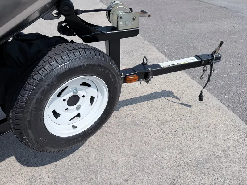 Slide: The Image of Close-up of a boat trailer with a spare tire and winch on asphalt. - 11