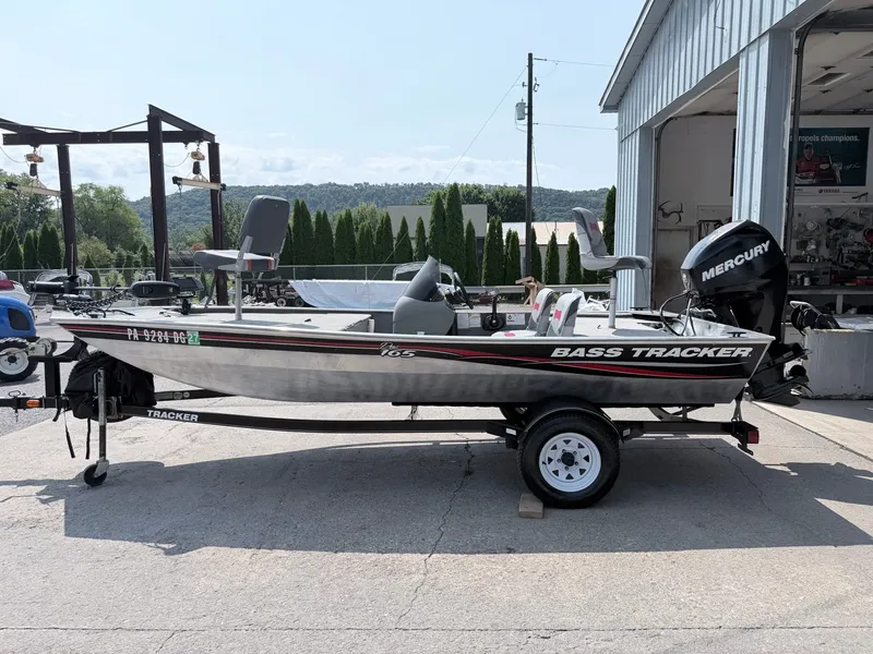 The Image of A silver 2011 Bass Tracker Pro 165 boat on a trailer in front of a building. - 1