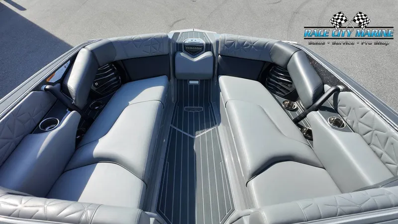 Slide: The Image of The image shows the interior of a 2022 Nautique Super Air Nautique G25 Paragon with gray upholstery and cup holders. - 28
