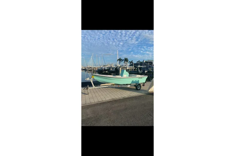 The Image of 2026 Exuma 14 Snookaholic boat on trailer by marina under blue sky. - 1