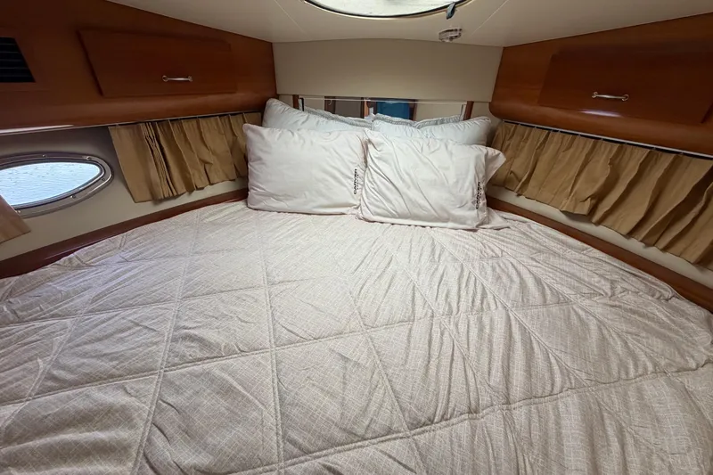 Slide: The Image of Cozy bedroom in 2005 Carver 396 Aft Cabin Motor Yacht with plush bedding and porthole window. - 16