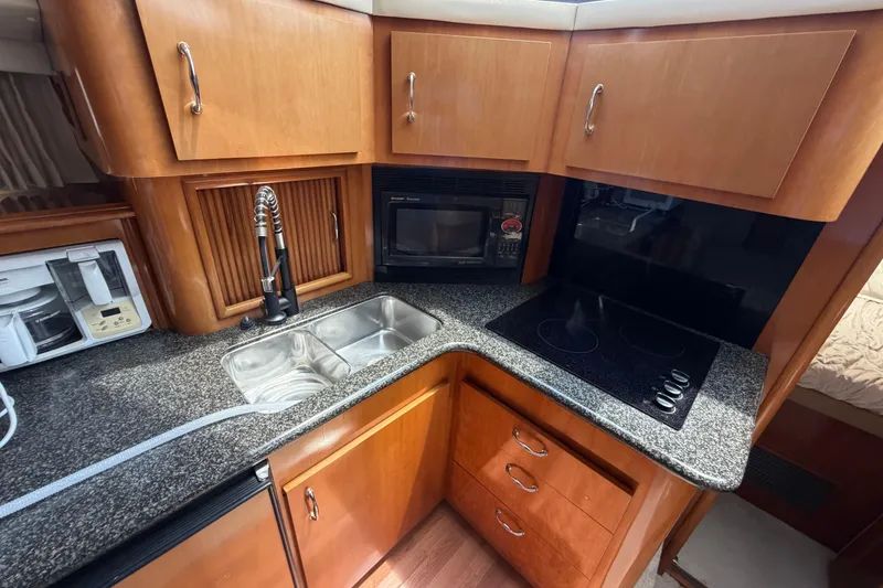 Slide: The Image of 2005 Carver 396 Aft Cabin Motor Yacht kitchen with sink, stove, and microwave. - 12