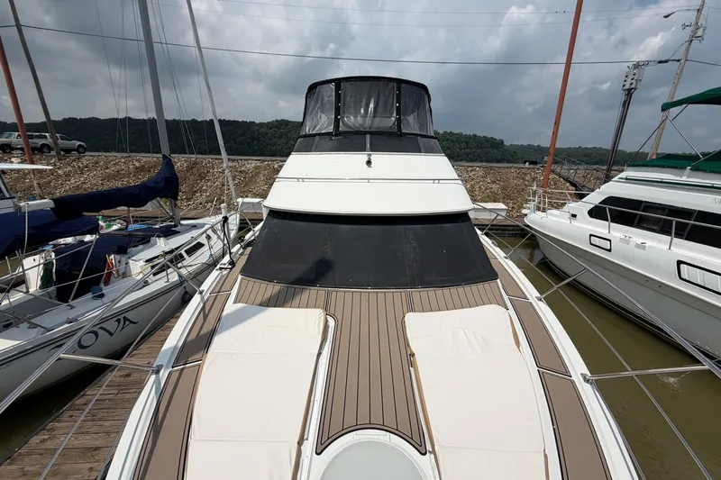 Slide: The Image of 2005 Carver 396 Aft Cabin Motor Yacht docked, showcasing sleek design and spacious deck. - 2